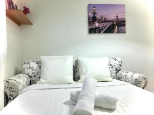 Un dormitorio con una cama y un sofá con toallas. en MaisonTevy en Pontault-Combault
