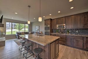 a kitchen with wooden cabinets and a large island with bar stools at Modern Huntsville Resort Retreat with Deck and Hot Tub in Huntsville