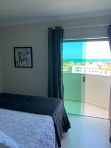 1 dormitorio con cama y ventana grande en Excelente Apartamento Vista Mar em Maragogi, en Maragogi