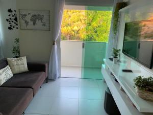 uma sala de estar com um sofá e uma grande janela em Excelente Apartamento Vista Mar em Maragogi em Maragogi