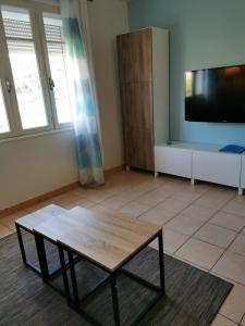 a living room with a coffee table and a flat screen tv at STUDIO 2 étoiles Rénové Proche des THERMES in Lamalou-les-Bains