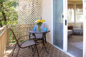 a table on a balcony with a vase of flowers at Bella Vista Bed and Breakfast in Coloma