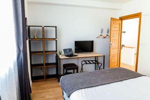 1 dormitorio con 1 cama y escritorio con ordenador en La Clé des Clos, en Beynes