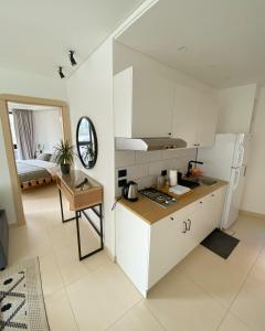 a kitchen with white cabinets and a table and a bed at Nu Fifty Two in Amman