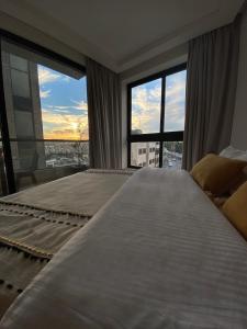 a bedroom with a large bed with a large window at Nu Fifty Two in Amman