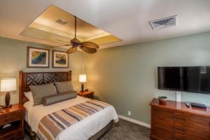 a bedroom with a bed and a flat screen tv at Keauhou Gardens Penthouse 22B at Kona Coast Resort in Kailua-Kona +16 photos