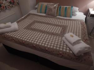 a bed with two towels on top of it at Two bedroom corporate and family stay with parking in popular location in Cambridge