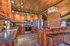 une cuisine avec des armoires en bois et des appareils en acier dans l'établissement Secluded Log Cabin with Decks, Views and Lake Access, à Elizabeth