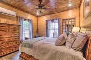 - une chambre avec un lit et un ventilateur de plafond dans l'établissement Secluded Log Cabin with Decks, Views and Lake Access, à Elizabeth