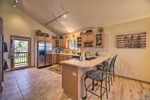 a kitchen with a large island with bar stools at Pagosa Springs Home with Deck and Grill, Walk to Town! in Pagosa Springs
