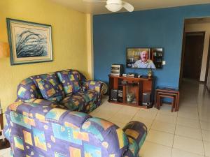 a living room with a couch and a flat screen tv at CASA COM 4 QUARTO EM BUZIOS - 2 SUITES - Perto de Tudo in Búzios