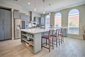 a kitchen with a large island with bar stools at Upscale EaDo Townhome - Walk to BBVA and Local Bars! in Houston