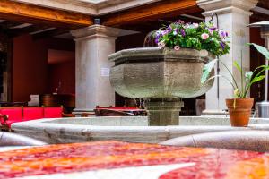 Una gran fuente de piedra con flores. en Hotel Casa Primavera Boutique & Spa, en San Miguel de Allende