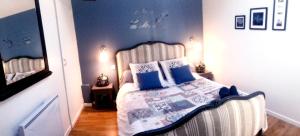 Cette petite chambre comprend un lit avec des oreillers bleus. dans l'établissement Halte cosy au porte de Bordeaux, à Tresses
