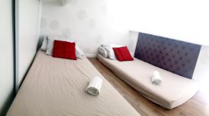 two beds with red and white pillows in a room at Halte cosy au porte de Bordeaux in Tresses