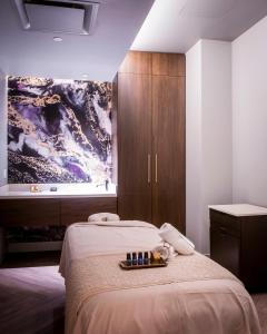 a bedroom with a bed, television and a painting on the wall at The Omni King Edward Hotel in Toronto