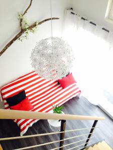 a room with a bed with red and white pillows at Halte cosy au porte de Bordeaux in Tresses