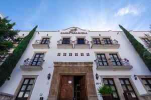 - un bâtiment blanc avec balcon dans une rue dans l'établissement Hotel Casa Primavera Boutique & Spa, à San Miguel de Allende