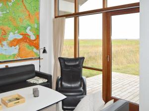 Thorsmindeにある8 person holiday home in Ulfborgの椅子とテーブル、窓が備わる客室です。