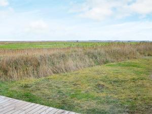 a view of a field with a wooden deck at 8 person holiday home in Ulfborg in Thorsminde