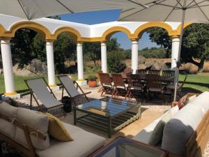 um pátio com cadeiras, uma mesa e um guarda-sol em Quinta do Amauriz em Évora
