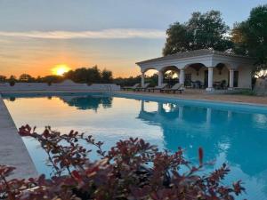 uma piscina com um gazebo e o pôr do sol em Quinta do Amauriz em Évora