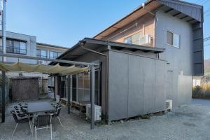 un edificio con tienda, mesa y sillas en Yoshimura ooike sense en Fujikawaguchiko