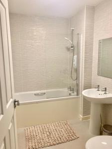 a bathroom with a shower and a tub and a sink at Kay's Place - Modern 3 Bed in Manchester