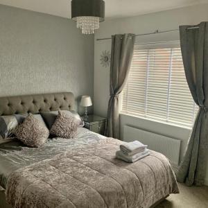 曼徹斯特的住宿－Kay's Place - Modern 3 Bed，一间卧室设有一张大床和一个窗户。