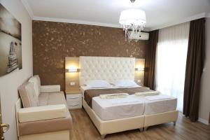 ein Schlafzimmer mit einem Bett, einem Stuhl und einem Kronleuchter in der Unterkunft "HOLIDAY" apartments & rooms in Ulcinj