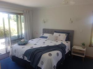 um quarto com uma cama grande e uma janela em Above the River Karapiro Bed & Breakfast em Karapiro