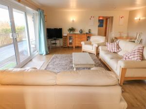 sala de estar con 2 sofás y TV en Clovermead Cottage, en Willington