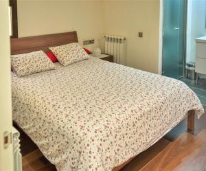 1 dormitorio con cama con edredón y almohadas en Apartamento Via Augusta 153, en Barcelona