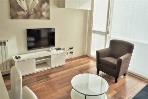 a living room with a chair and a television at Apartamento Via Augusta 153 in Barcelona