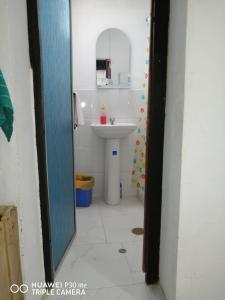 ein Badezimmer mit einem weißen Waschbecken und einem Spiegel in der Unterkunft Asiriq Wasi Casita de huéspedes in Cusco