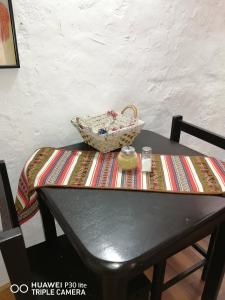 una mesa con una cesta encima en Asiriq Wasi Casita de huéspedes, en Cusco