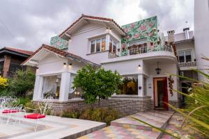 een wit huis met een balkon en een patio bij Allegra Dalila Casa Hotel-Arte in Tandil