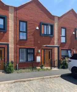 un bâtiment en briques avec une voiture garée devant lui dans l'établissement Kay's Place - Modern 3 Bed, à Manchester