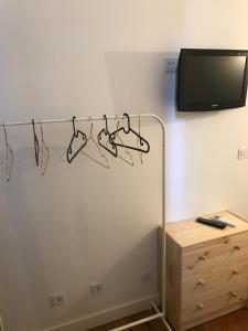 a rack of hangers in a room with a tv at Saldanha Pool & Garden in Lisbon