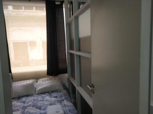 a small bedroom with a bed and a window at DEPARTAMENTO CENTRICO FLORIDA AL 500 in Buenos Aires