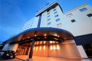 un edificio con un'auto parcheggiata di fronte di Quintessa Hotel Iseshima a Shima