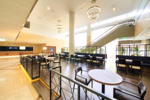 a cafeteria with tables and chairs in a building at Quintessa Hotel Iseshima in Shima