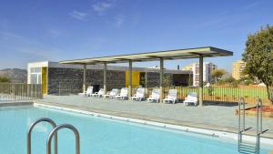 a pool with chairs and a pavilion next to a building at Panorámico Viña del Mar in Viña del Mar
