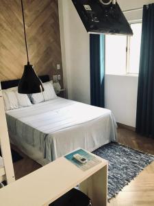 um quarto com uma cama com uma mesa e uma janela em Prado Guest House 2 em Florianópolis