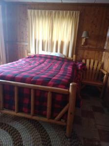 
a bedroom with a bed and a dresser at FireHouse Inn in Saint Ignace
