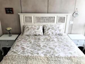 um quarto com uma cama com uma colcha e almofadas brancas em Concón Costa de Montemar Departamento, 3 dormitorios em Concón