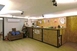 a room with a bar and a couch and a clock at Good Night Hotel in Yangmei