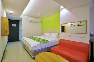 1 dormitorio con 1 cama y 1 sofá rojo en Good Night Hotel en Yangmei