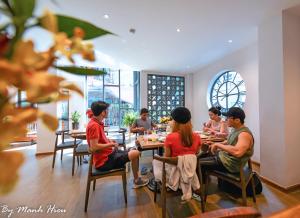 a group of people sitting at tables in a restaurant at Mojzo Inn Boutique Hotel in Nha Trang