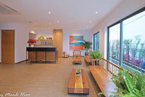 a living room with a grand piano and benches at Mojzo Inn Boutique Hotel in Nha Trang